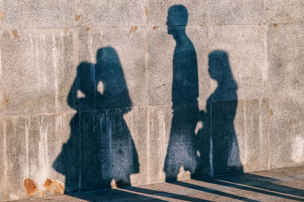 Shadows of four people against a concrete wall